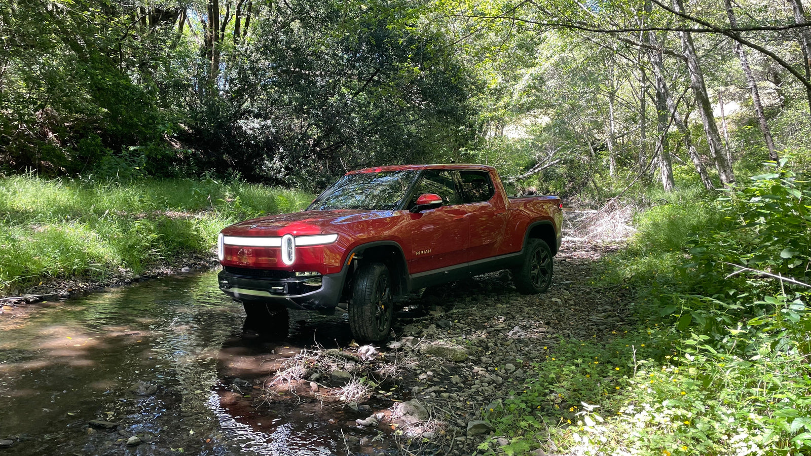 Red Canyon Rivian R1T crossing a creek 